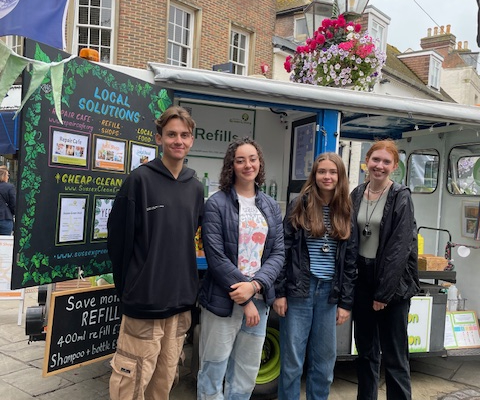 IMG_4309 A group of envirinmentally conscious youths standing next to an eco milk float