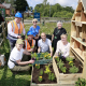 A group of volunteers on a sunny day installing a bug hotel made from pre-loved pallets in a new housing development