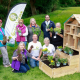 A group of people displaying a pollination education station otherwise known as a luxury bug hotel